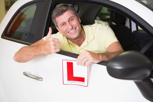 Mann gestikuliert mit erhobenem Daumen und hält Fahrschüler-Schild hoch — Stockfoto