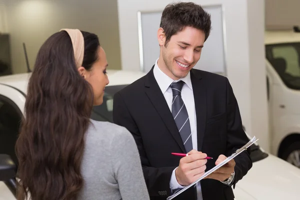 Vendedor mostrando área de transferência para assinar com o cliente — Fotografia de Stock