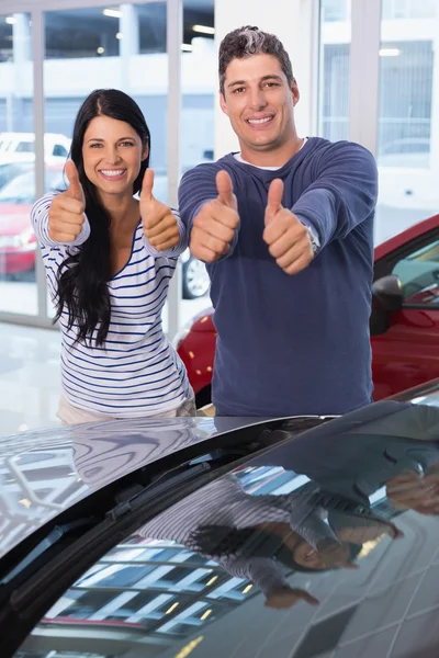 Sonriente pareja dando pulgares hacia arriba —  Fotos de Stock