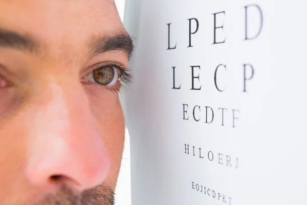 Сосредоточенный человек на глазных пробных буквах — стоковое фото