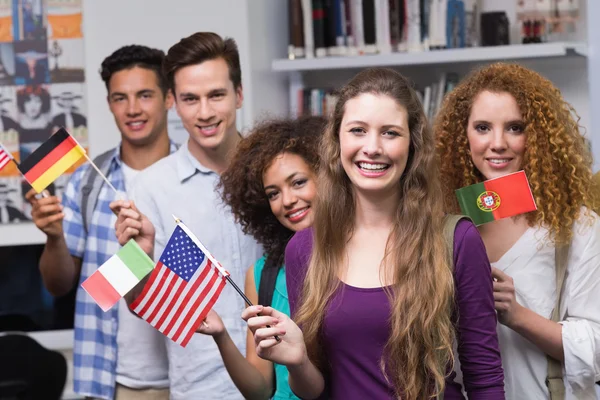 Щасливі студенти махають міжнародними прапорами — стокове фото