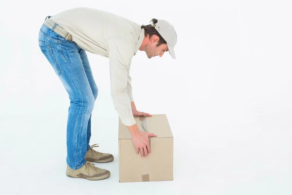 Delivery man picking cardboard box — Stock Photo, Image