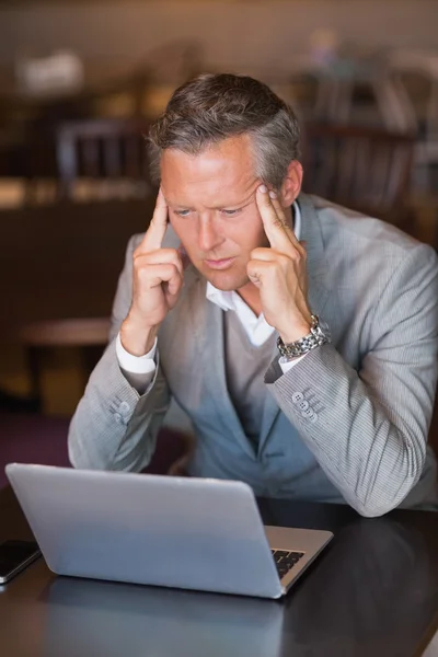 Ernstige zakenman met behulp van zijn laptop — Stockfoto