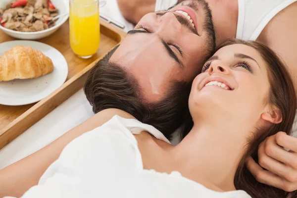 Jovem casal tomando café da manhã na cama — Fotografia de Stock