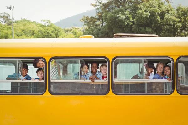 Mignonnes élèves souriant à la caméra dans le bus scolaire — Photo