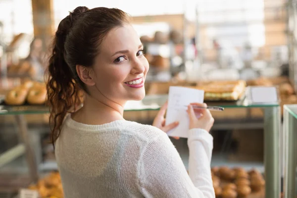 Femme vérifiant sa liste d'achats — Photo