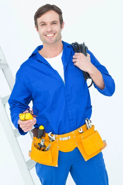 Electrician with wire roll and multimeter — Stock Photo, Image