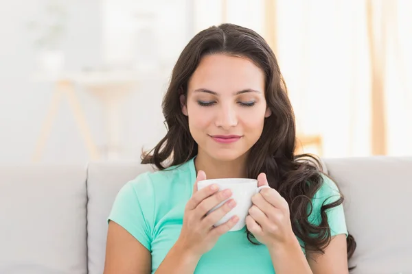 Mooie brunette ontspannen op de Bank — Stockfoto