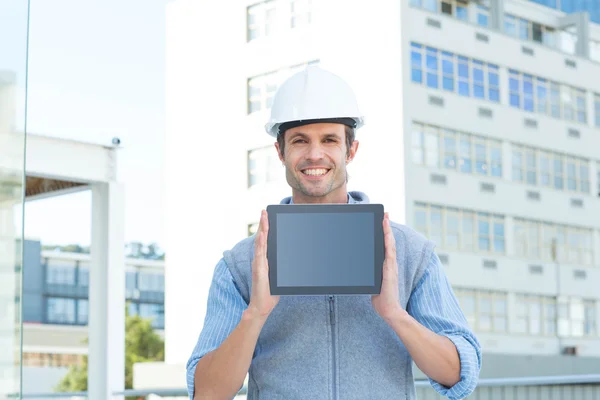 Bonito arquiteto masculino mostrando tablet — Fotografia de Stock