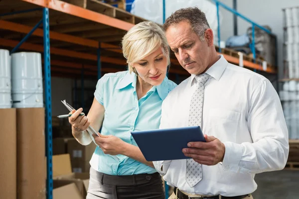 Warehouse managers looking at tablet pc — Stock Photo, Image