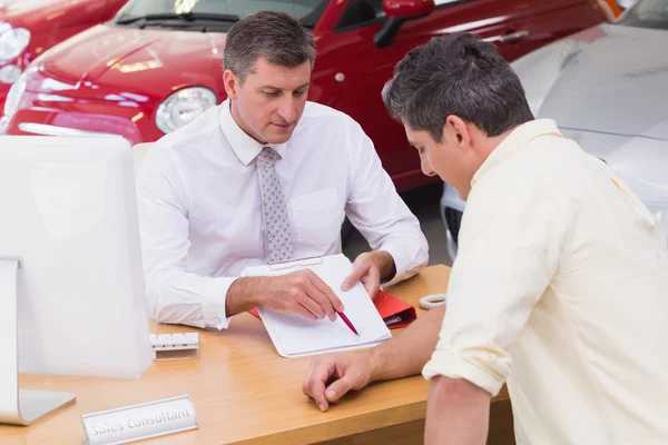 Salesman показує клієнту, де підписати угоду — стокове фото