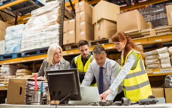 Warehouse managers and worker working on laptop — Stock Photo, Image