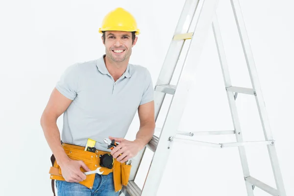 Werknemer leunend op stap ladder — Stockfoto