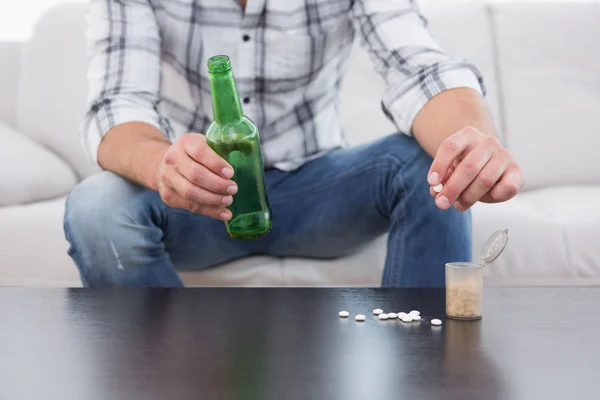 Man with a beer and his medicine laid — Stock Photo, Image