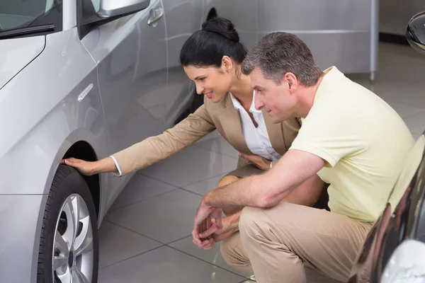 Femme d'affaires et client discutant pneu de voiture — Photo