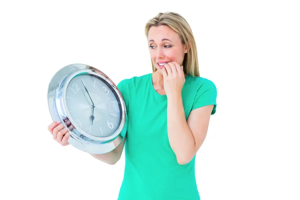 Nervous blonde holding clock — Stock Photo, Image