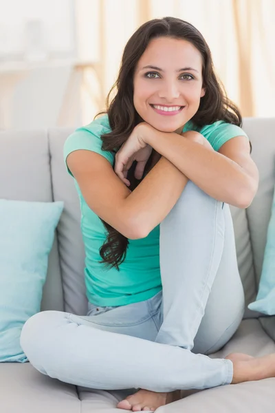 Pretty brunette sitting on the couch — Stock Photo, Image