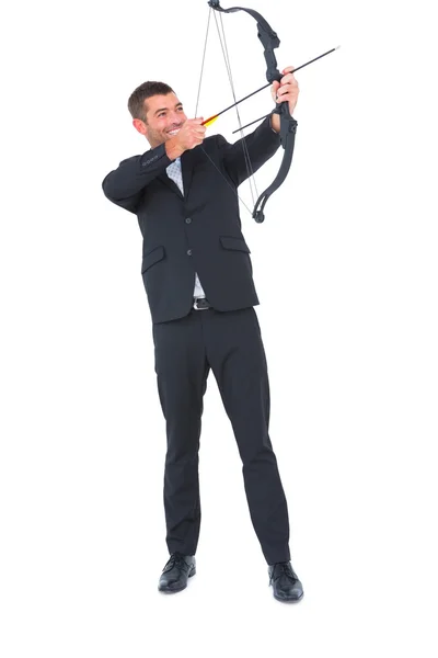 Businessman shooting a bow and arrow — Stock Photo, Image