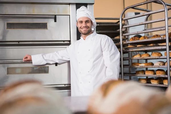 Baker leaning on professional oven — Stock Photo, Image