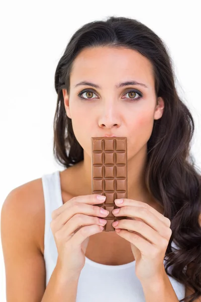 Mooie brunette eten bar van chocolade — Stockfoto