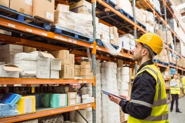 Focused warehouse manager writing on clipboard — Stock Photo, Image