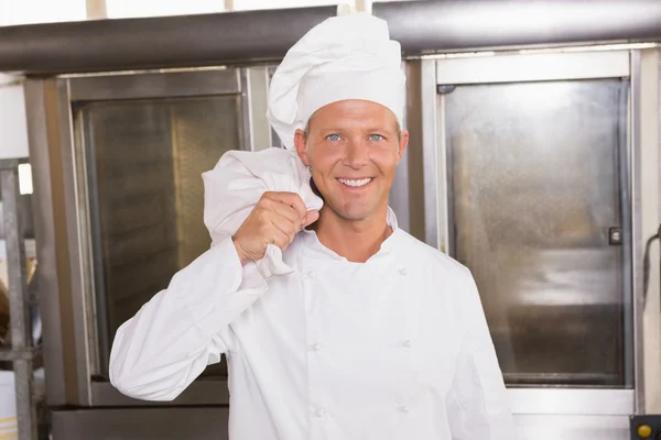 Panadero sonriente sosteniendo bolsa de harina — Foto de Stock