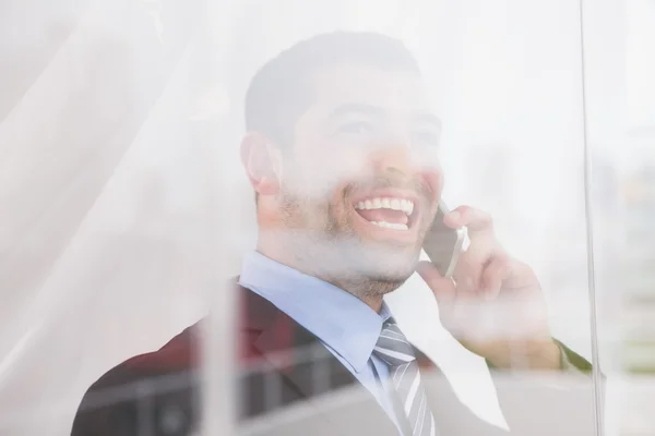 Lachende zakenman uit raam op camera op de telefoon — Stockfoto