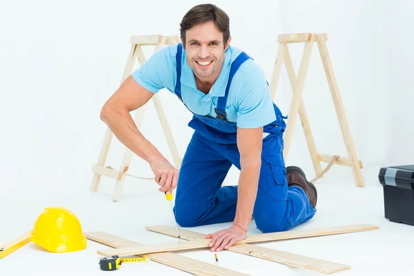 Repairman fixing screw on plank — Stock Photo, Image