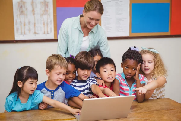 Učitel a žáci při pohledu na notebook — Stock fotografie