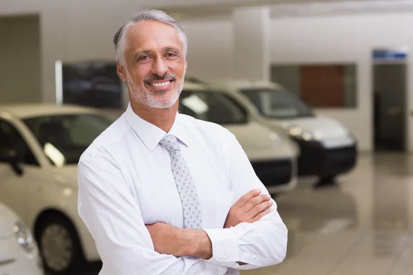 Smiling businessman standing with arms crossed — Stock Photo, Image