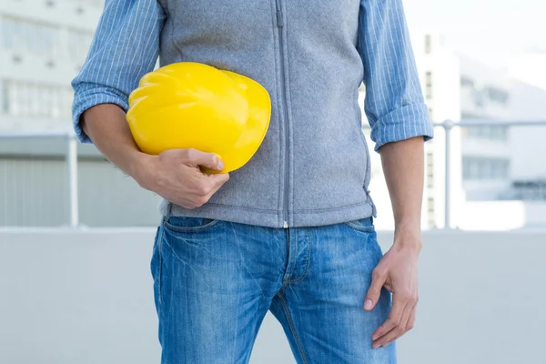 Arquiteto segurando chapéu duro amarelo — Fotografia de Stock