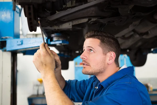 Focused mechanic adjusting the wheel — Stock Photo, Image