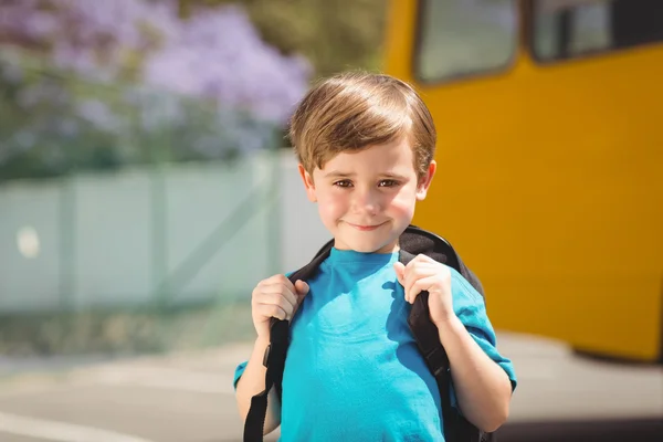 Lindo alumno sonriendo a la cámara por el autobús escolar — Foto de Stock