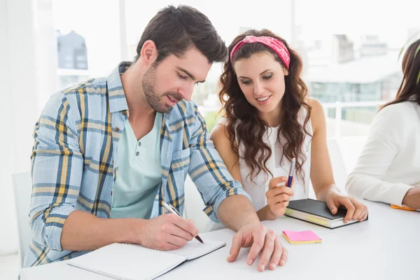 Fröhliche Kollegen sitzen und arbeiten — Stockfoto