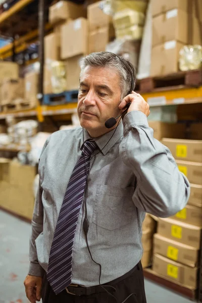 Gestionnaire focalisé parlant dans un casque — Photo