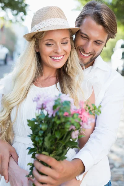 Atractiva pareja sonriendo a las flores — Foto de Stock
