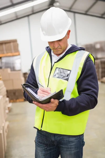 Trabajador de almacén serio con diario — Foto de Stock