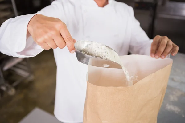 Baker prend de la farine avec une cuillère — Photo