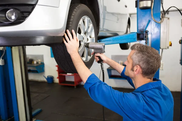 Mechanic adjusting the tire wheel — Stock Photo, Image