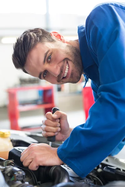 Mechanic using screwdriver on engine — Stock Photo, Image