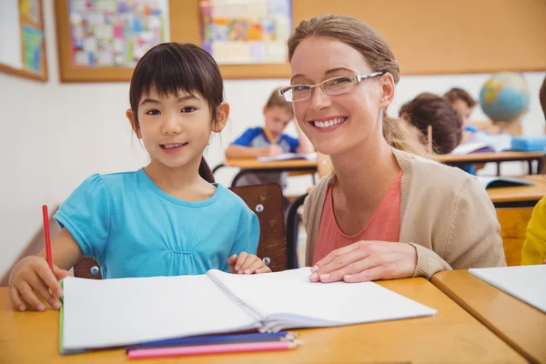 Schöne Lehrerin hilft Schülerin im Klassenzimmer — Stockfoto