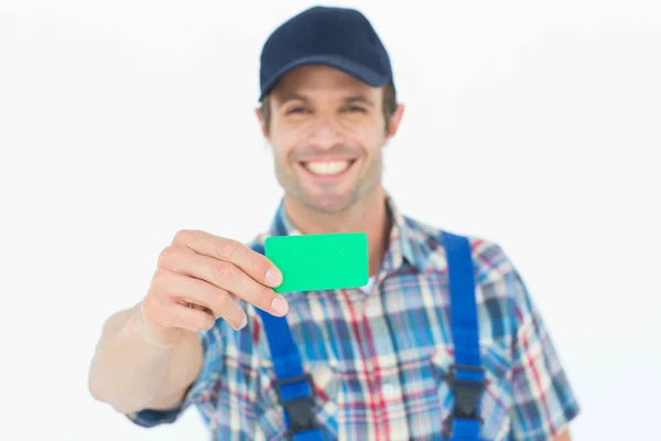 Happy plumber showing green card — Stock Photo, Image