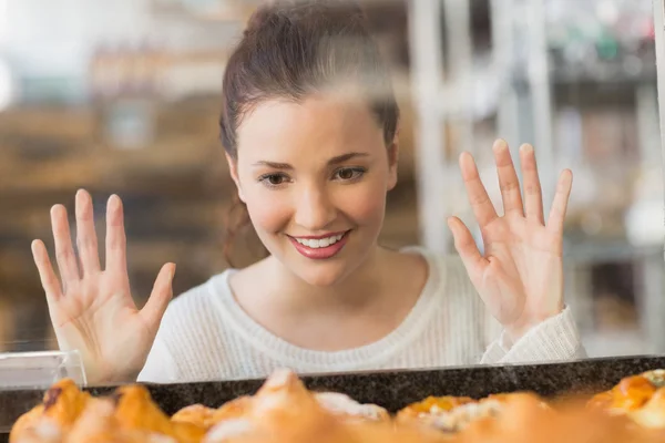 Pretty brunette looking at pastrys — Stock Photo, Image