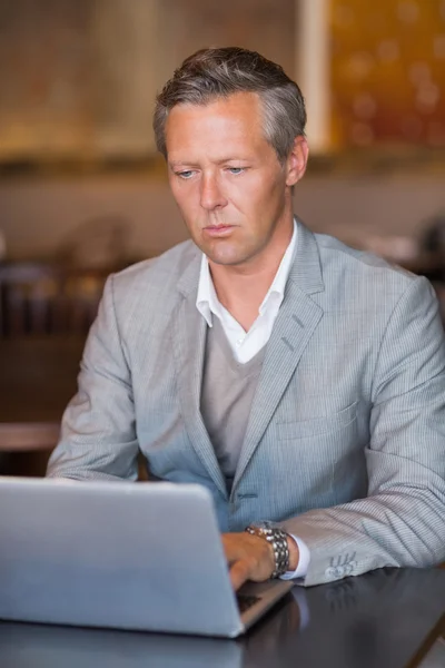 Ernstige zakenman met behulp van zijn laptop — Stockfoto
