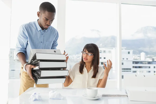 Hombre dando pila de archivos a colega — Foto de Stock