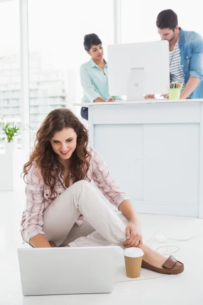 Affärskvinna som sitter på golvet med laptop — Stockfoto