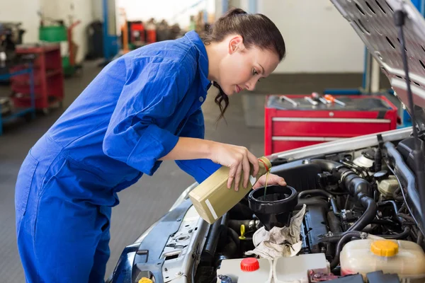 Mechanic pouring oil into car — Stock Photo, Image