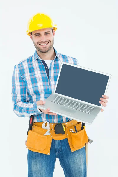 Glücklicher Bauarbeiter zeigt Laptop — Stockfoto