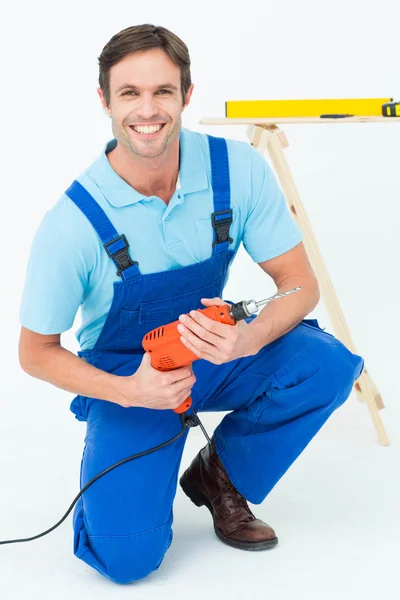 Feliz carpintero sosteniendo la máquina de perforación —  Fotos de Stock