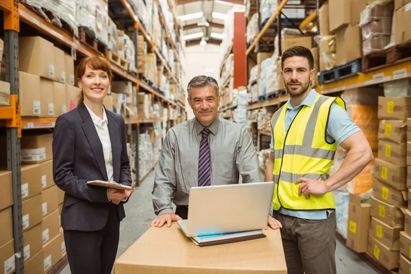 Smiling warehouse team working together on laptop — Stock Photo, Image